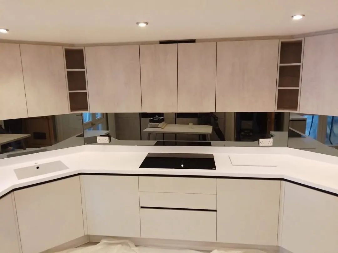 Grey mirror splashback fitted in compact kitchen