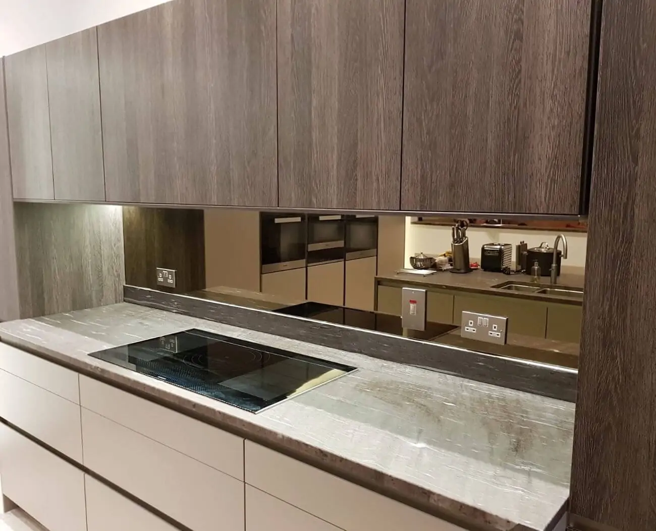 Vertical shot of bronze mirror splashback installed behind a kitchen hob