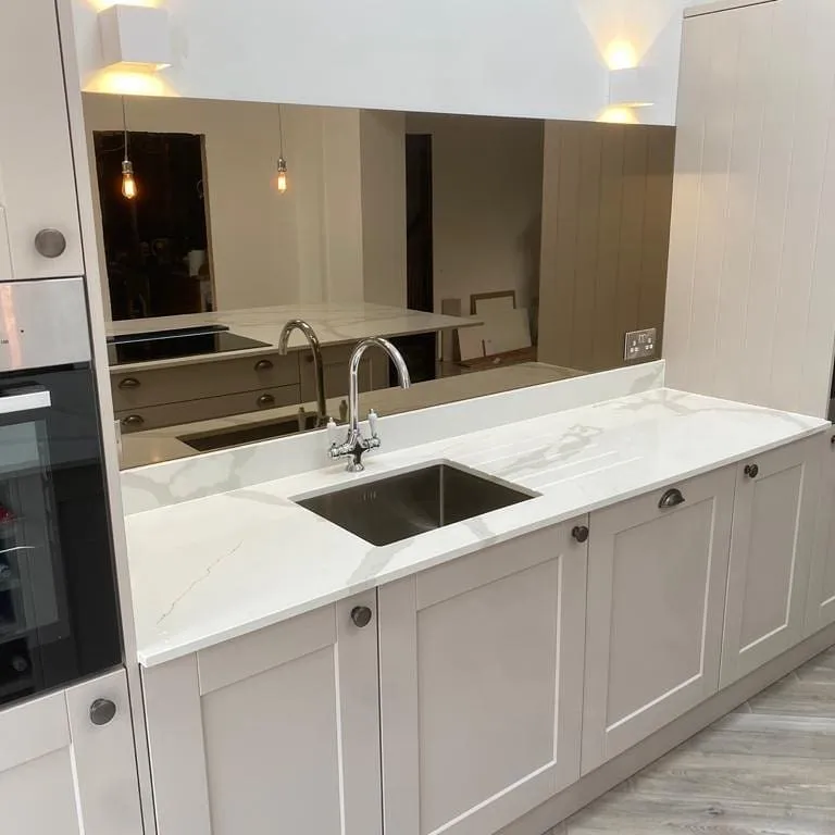 Grey mirror splashback fitted in compact kitchen